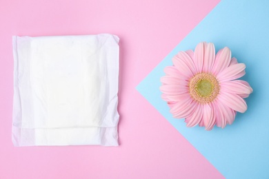 Photo of Flat lay composition with menstrual pad and gerbera flower on color background. Gynecological care