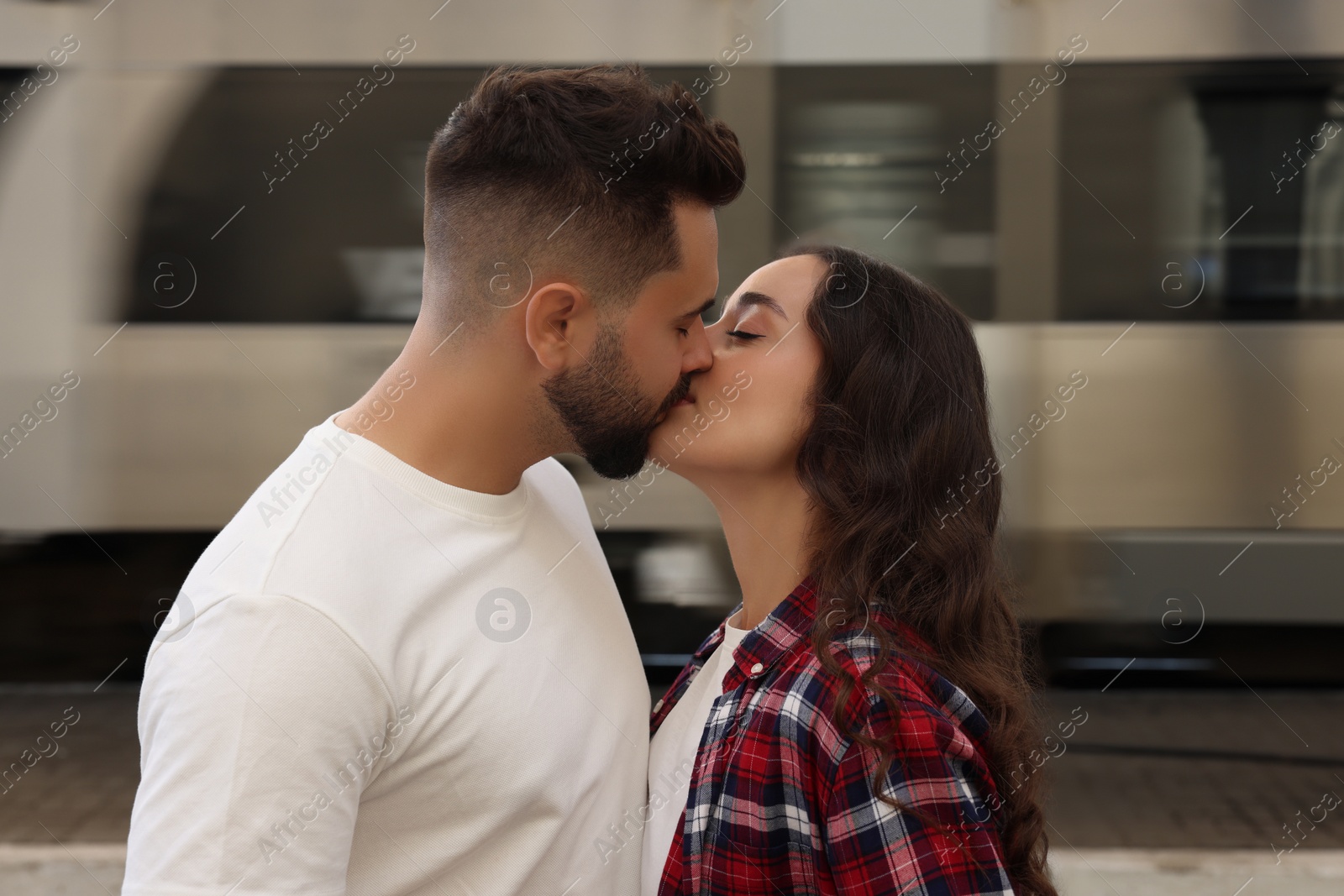 Photo of Long-distance relationship. Beautiful couple kissing on platform of railway station