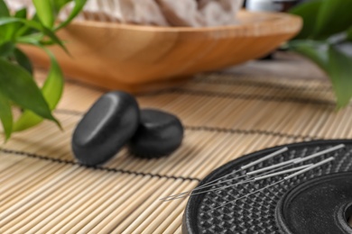 Plate with acupuncture needles on table, closeup