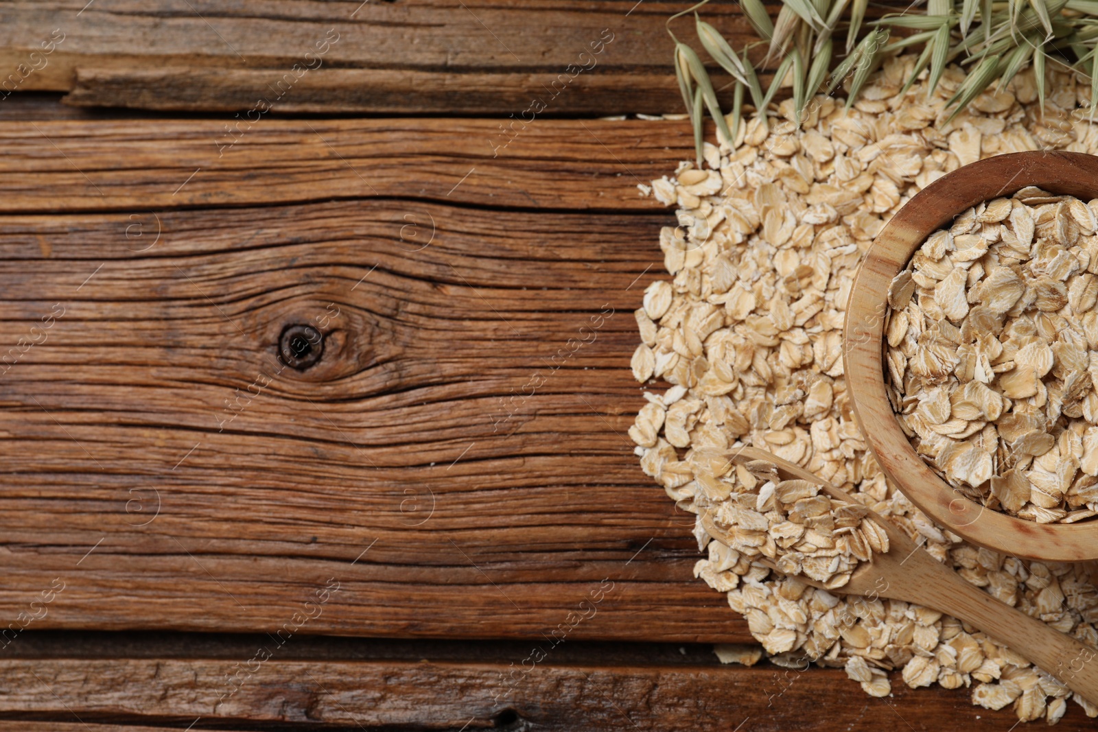 Photo of Oatmeal and florets on wooden table, flat lay. Space for text