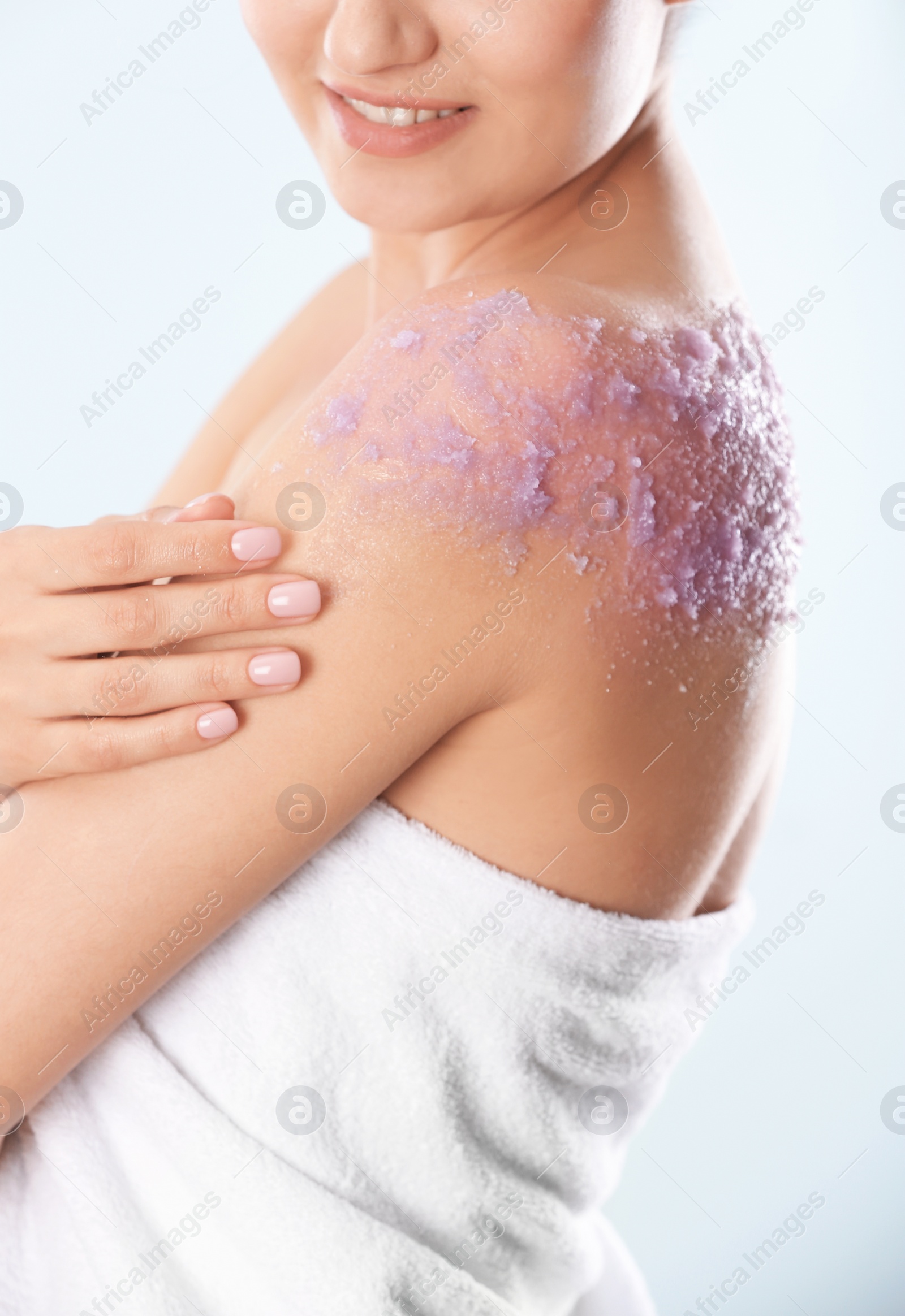 Photo of Young woman with natural scrub on her body against light background