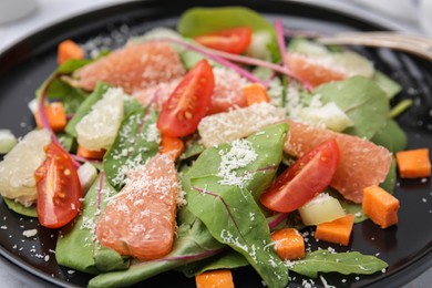 Photo of Delicious salad with pomelo, tomatoes and cheese in plate, closeup