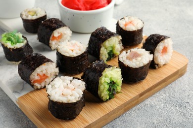 Photo of Tasty sushi rolls served on grey table, closeup