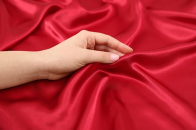 Woman touching smooth silky fabric, closeup view