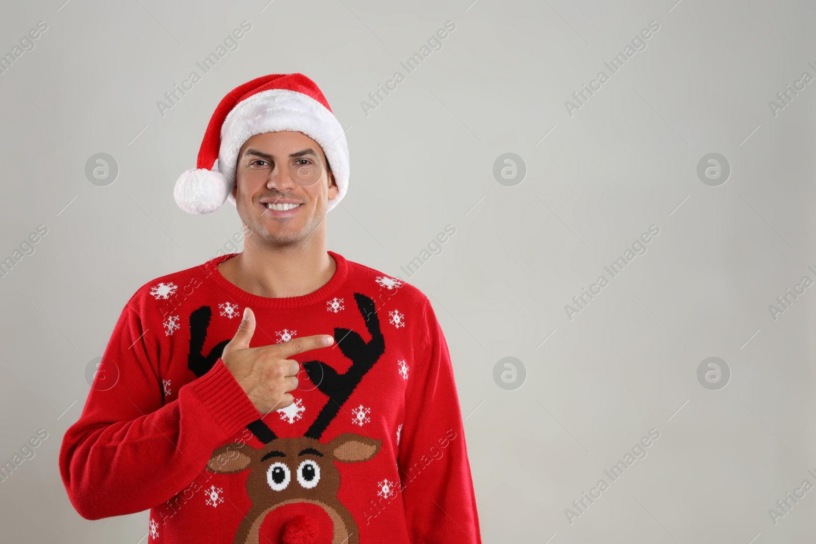 Photo of Happy man in Santa hat on grey background, space for text. Christmas countdown