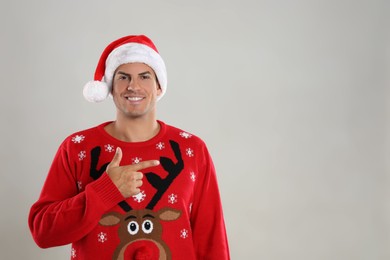 Photo of Happy man in Santa hat on grey background, space for text. Christmas countdown