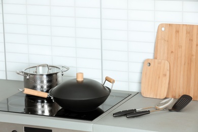 Photo of Set of clean cookware and utensils on table in kitchen