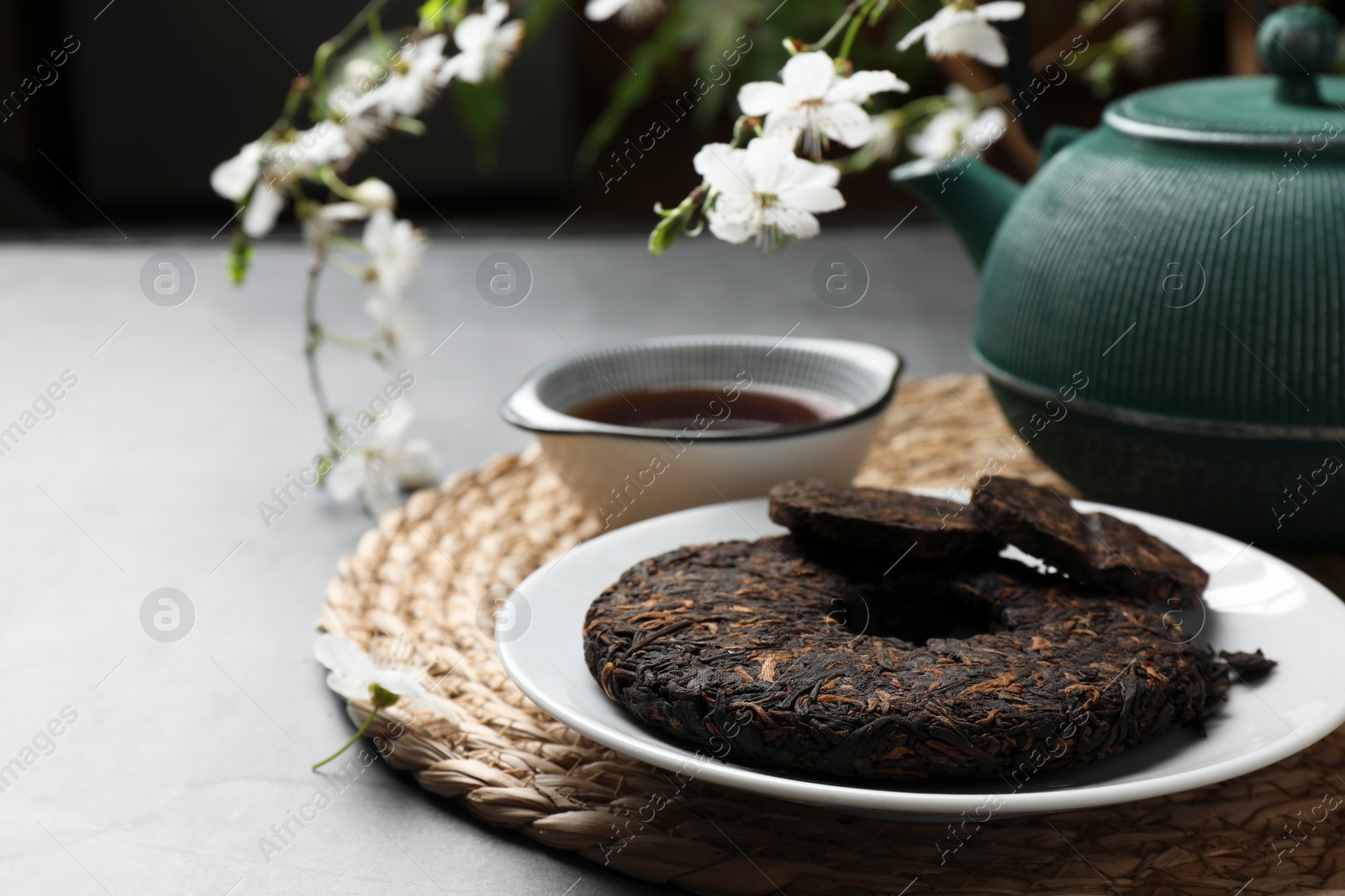 Photo of Round shaped pu-erh tea on light grey table, closeup. Space for text