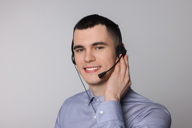 Photo of Hotline operator with headset on light grey background