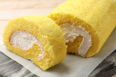 Photo of Cut delicious cake roll on board, closeup