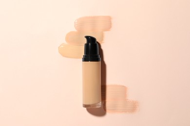 Photo of Liquid foundation and swatches on beige background, top view