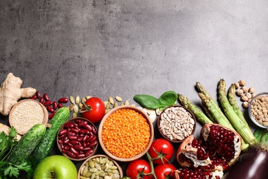 Fresh vegetables, fruits and seeds on grey table, flat lay. Space for text