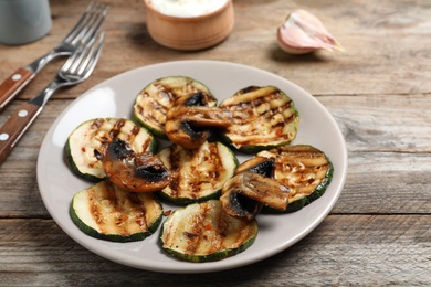 Photo of Grilled zucchini slices served on wooden table