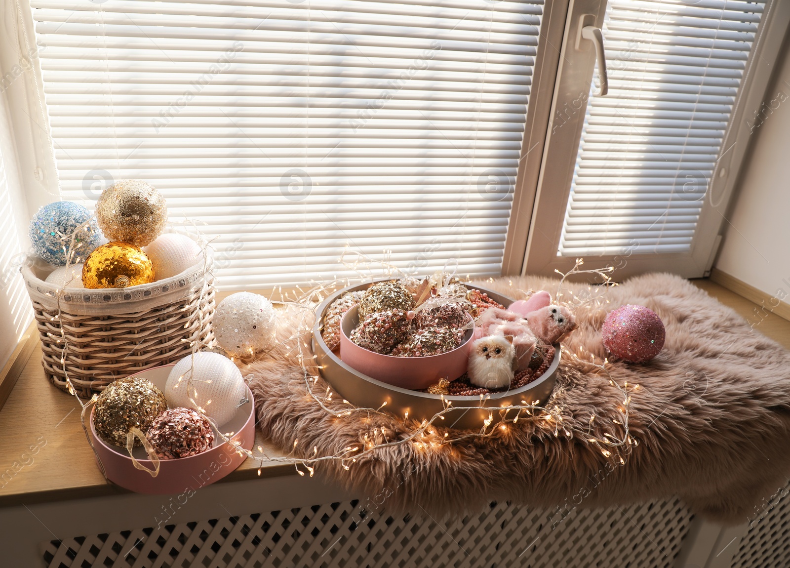 Photo of Beautiful Christmas tree baubles, toys and fairy lights on window sill indoors