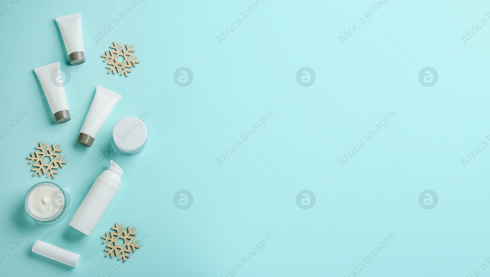 Photo of Flat lay composition with different cosmetic products on turquoise background, space for text. Winter care