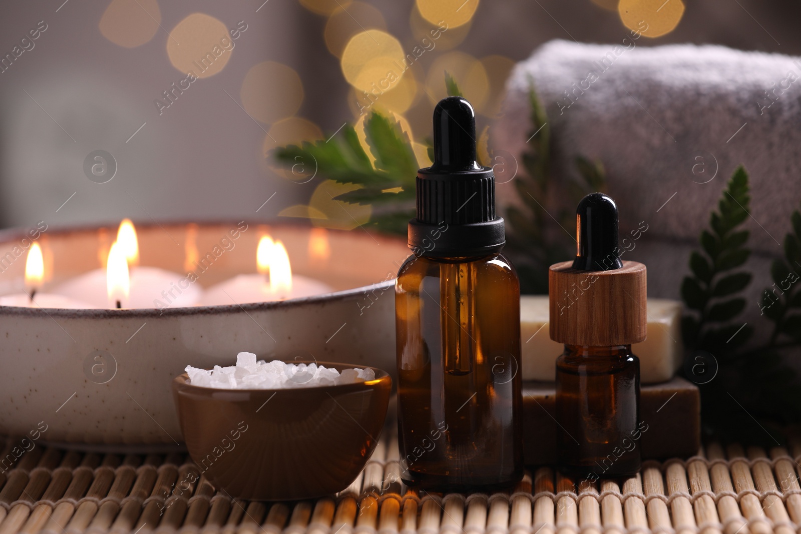 Photo of Beautiful composition with different spa products on table against blurred lights, closeup