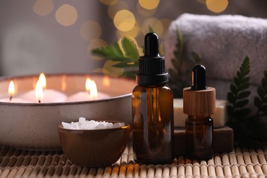 Photo of Beautiful composition with different spa products on table against blurred lights, closeup