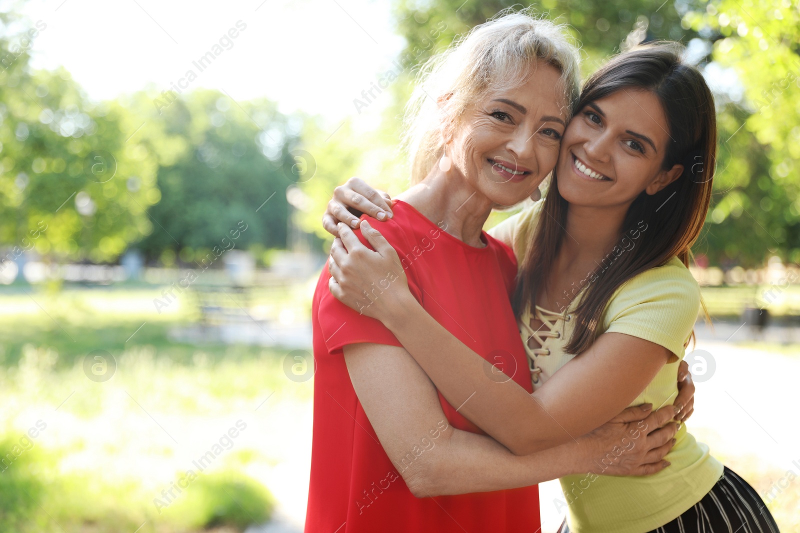 Photo of Mature woman with granddaughter in park on sunny day. Space for text