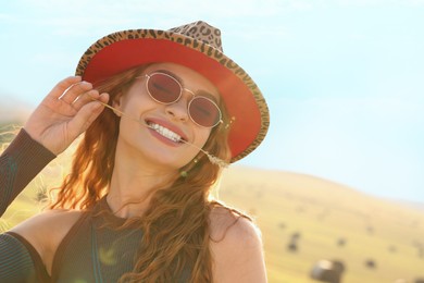 Beautiful happy hippie woman with spikelet in field, space for text
