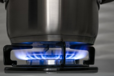 Pot on modern gas cooktop in kitchen, closeup