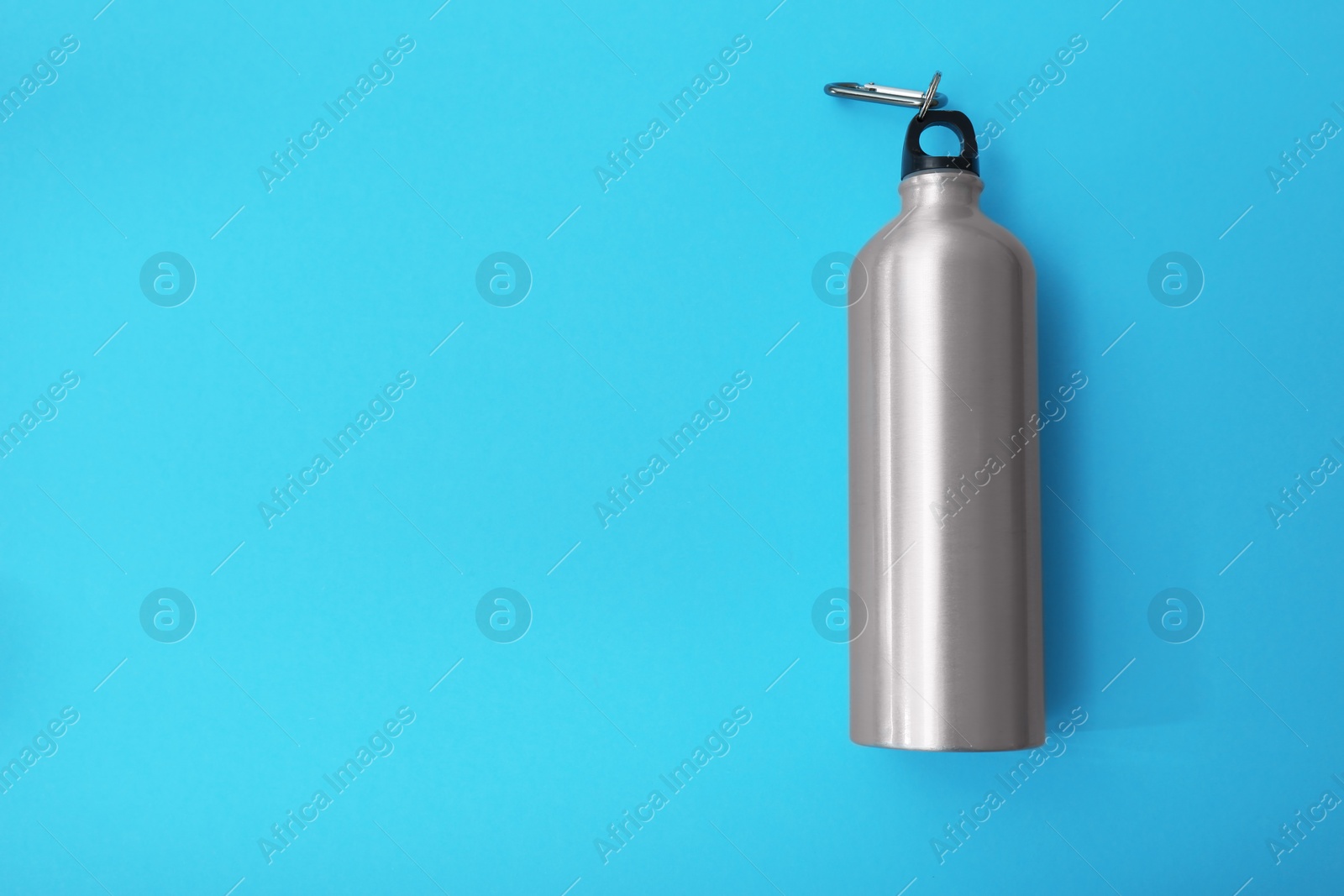 Photo of Sport bottle with space for text on color background, top view