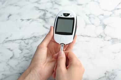 Woman using glucometer at table. Diabetes test