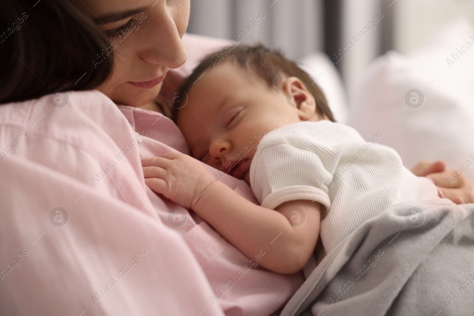 Photo of Mother with her sleeping newborn baby in bed, closeup