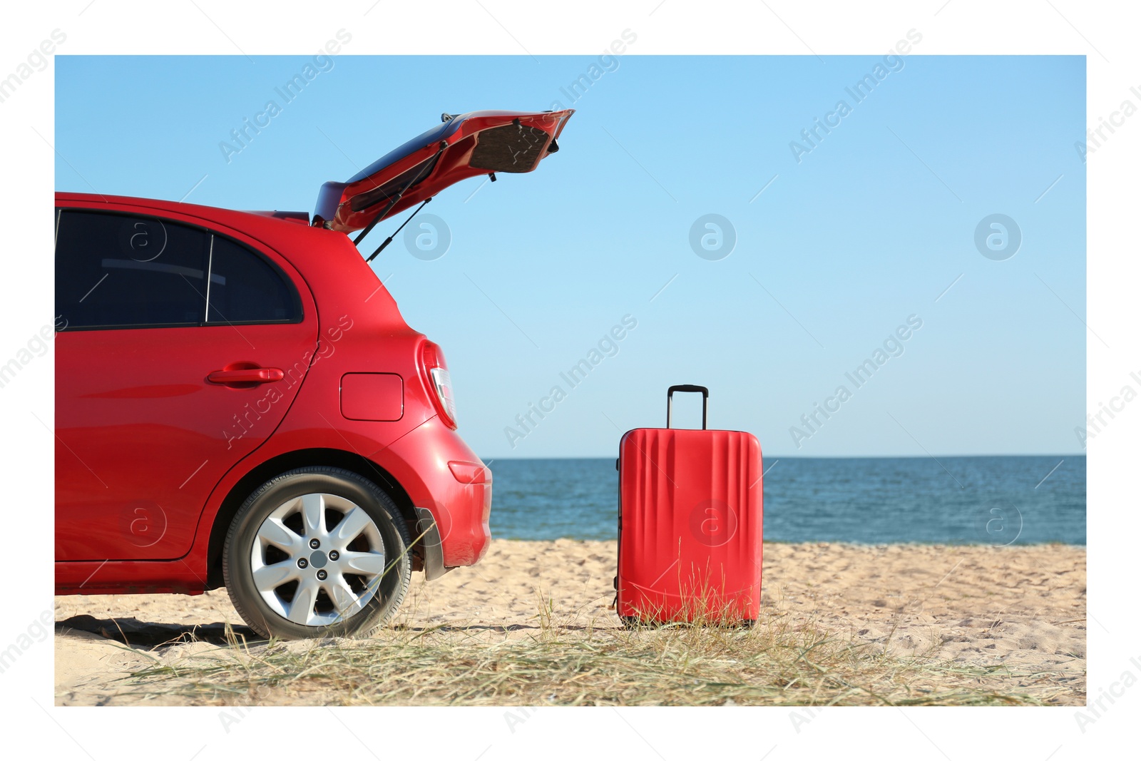 Image of Paper photo. Modern car and red suitcase on sand near sea 