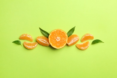 Composition with tangerines and leaves on color background, flat lay