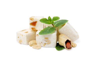 Photo of Pieces of delicious nougat, peanuts and mint on white background