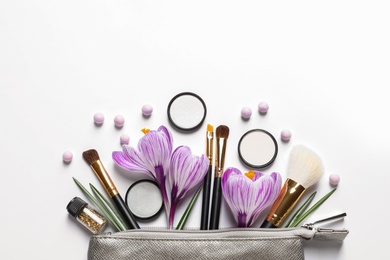 Photo of Makeup products, flowers and cosmetic bag on white background, top view