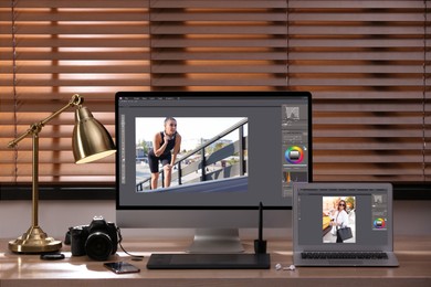 Photo of Retoucher's workplace. Computer and laptop with photo editor applications, camera, graphic tablet on table indoors