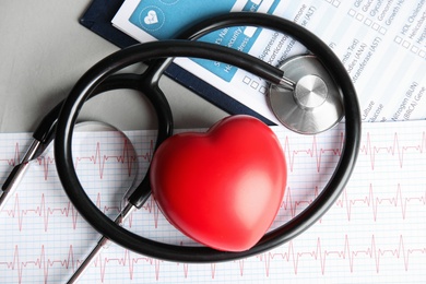 Flat lay composition with red heart and stethoscope on table. Cardiology concept