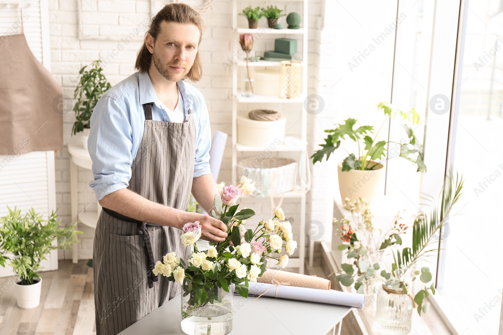 Photo of Male florist creating floral composition at workplace