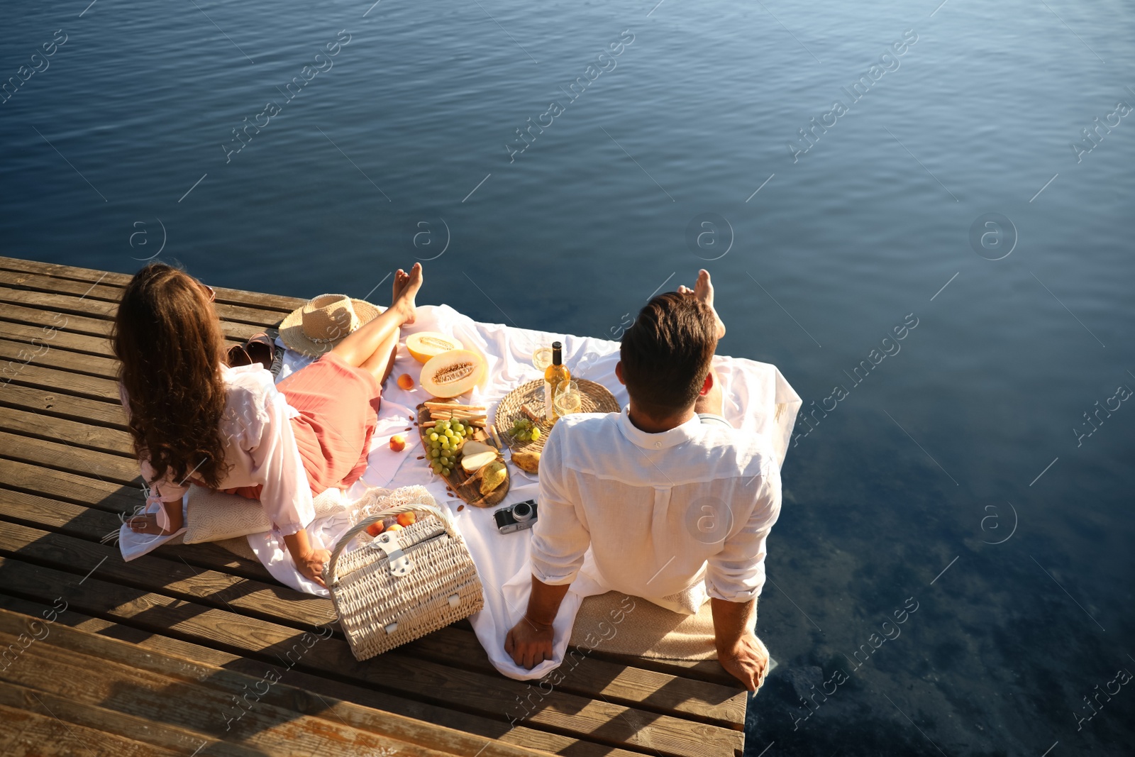 Photo of Happy couple spending time on pier at picnic