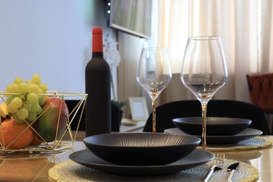 Bottle of wine and fruits on table served for dinner indoors