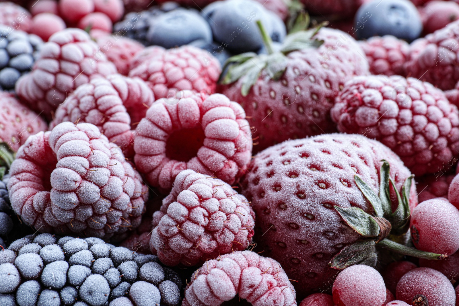 Photo of Mix of different frozen tasty berries as background, closeup