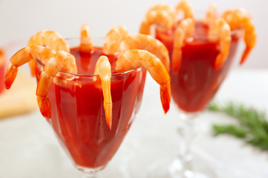 Photo of Delicious shrimp cocktail with tomato sauce served on  table, closeup