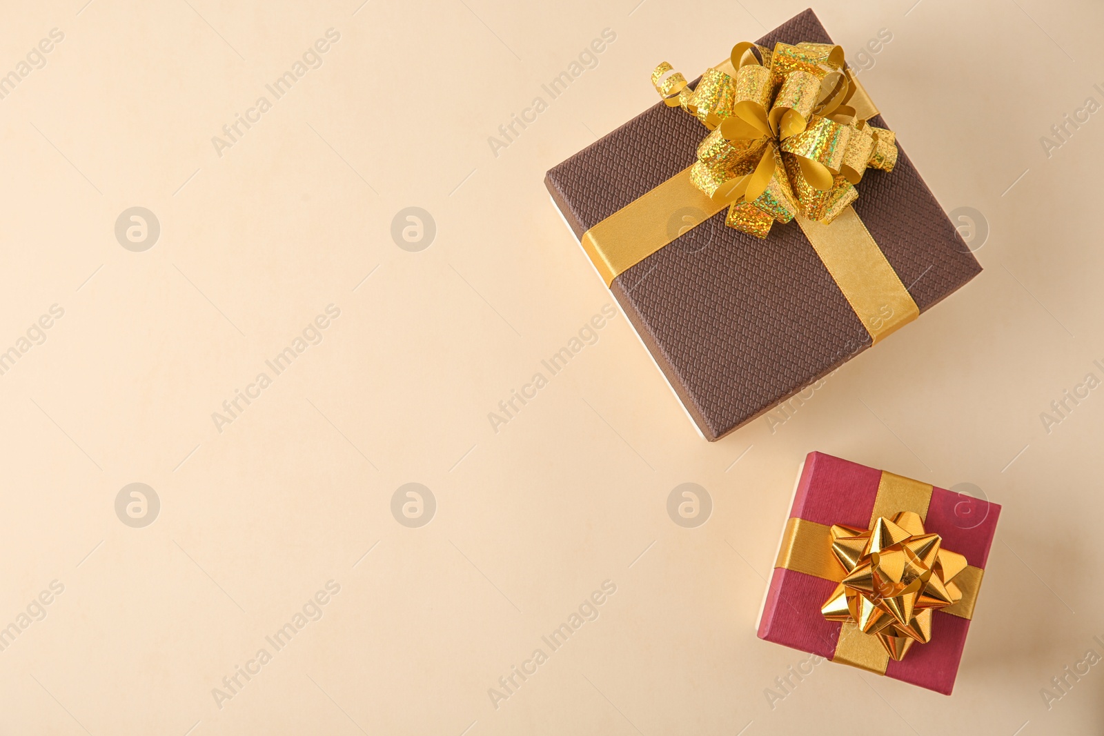 Photo of Beautiful gift boxes on beige background, flat lay. Space for text