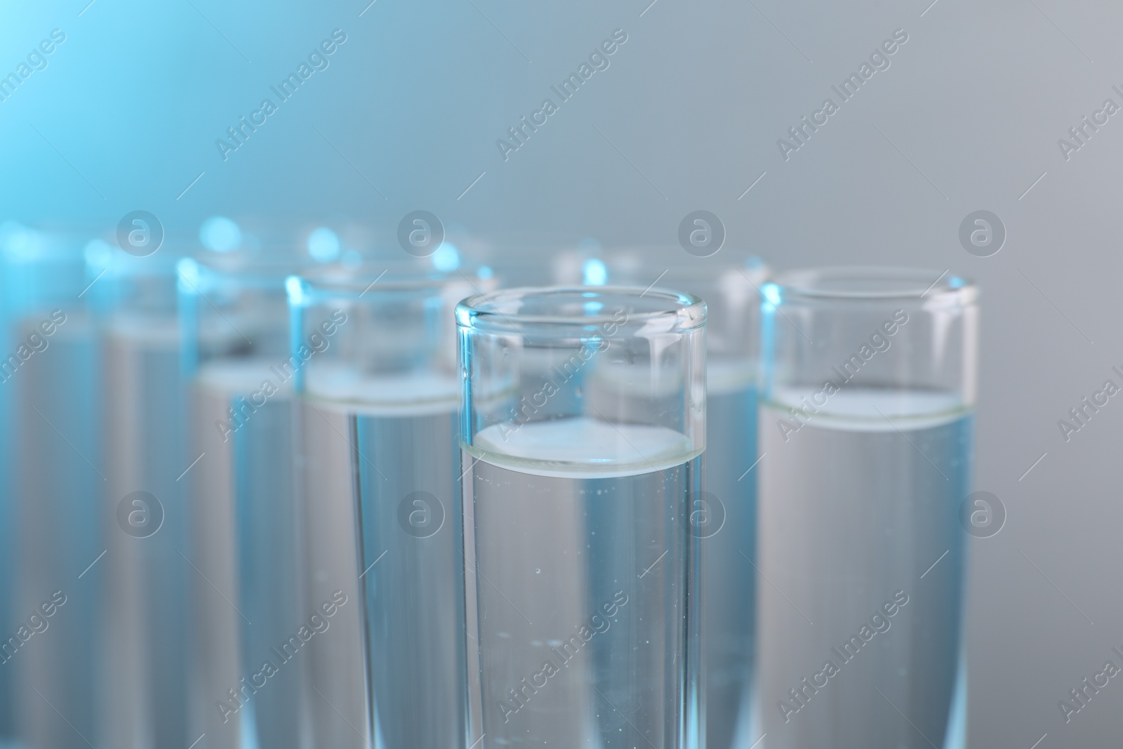 Photo of Laboratory analysis. Test tubes with liquid samples on color background, closeup