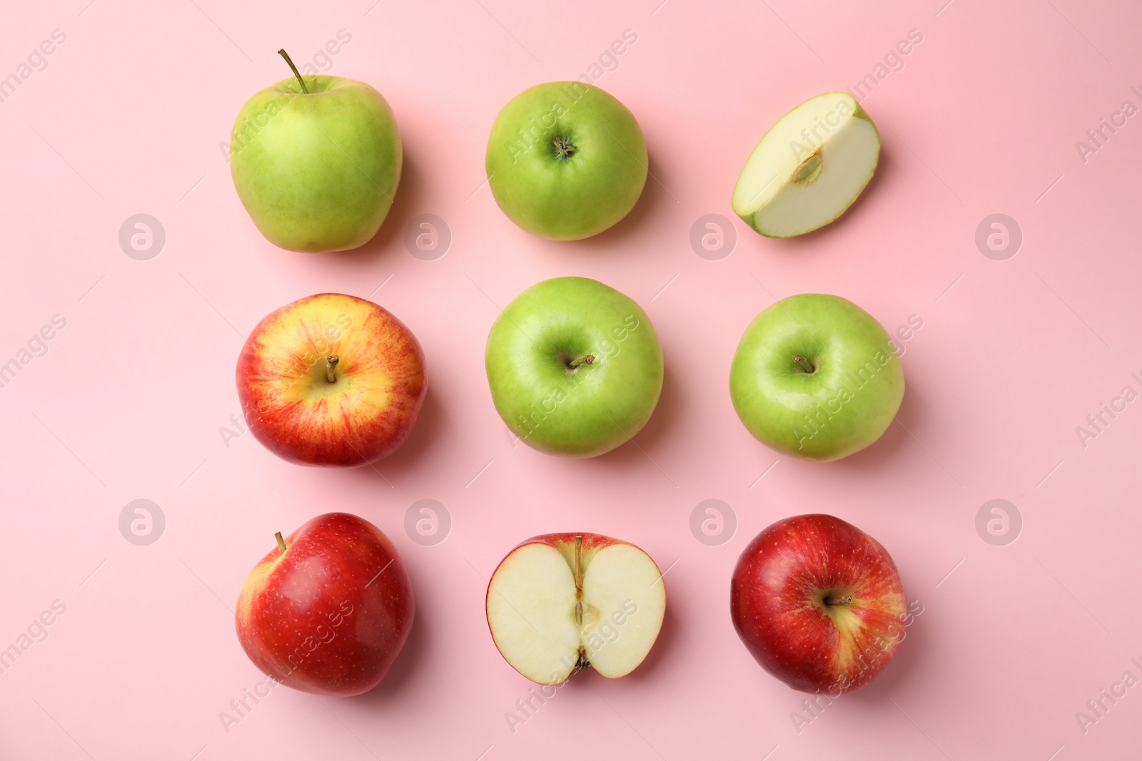 Photo of Many different ripe apples on pink background, flat lay