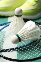 Photo of Feather badminton shuttlecocks and rackets on court, closeup