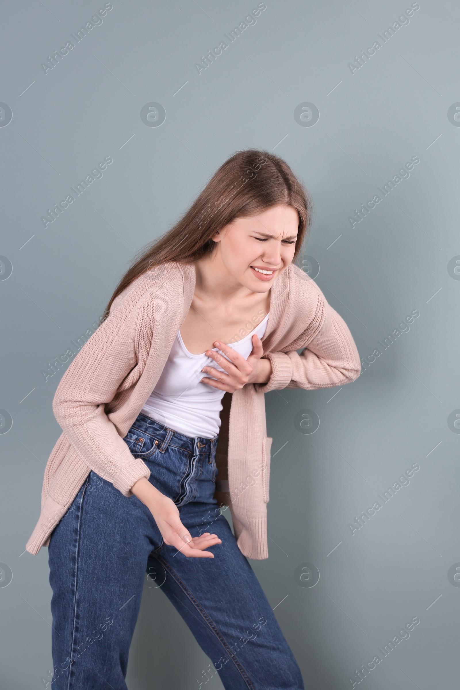 Photo of Young woman having heart attack on color background