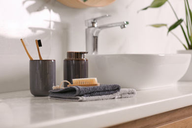 Photo of Toiletries and stylish vessel sink on light countertop in modern bathroom