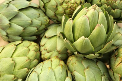 Photo of Many fresh raw artichokes as background, closeup