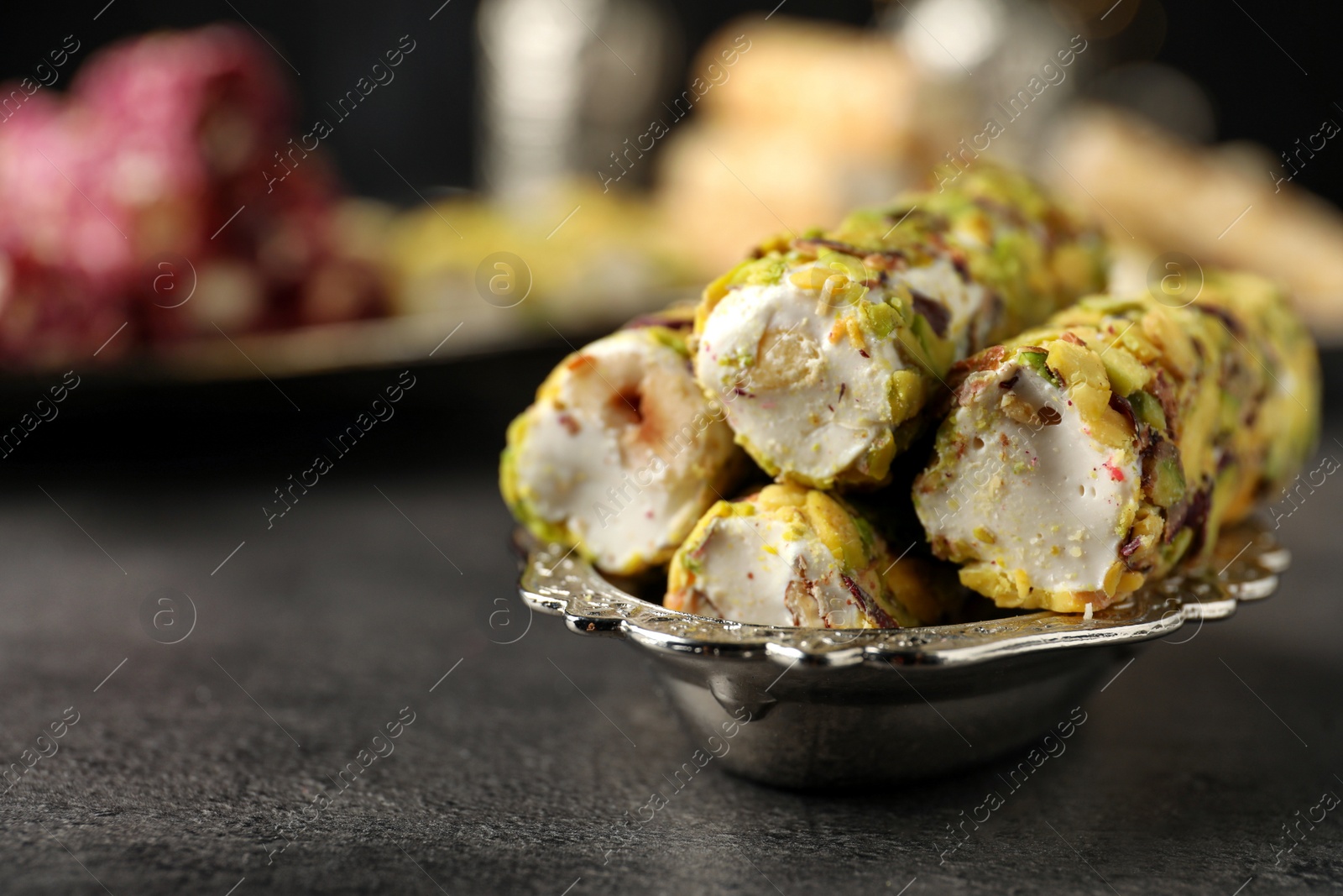 Photo of Tasty turkish delight dessert on dark table, closeup. Space for text