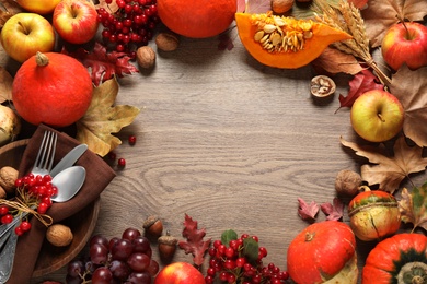 Frame made of autumn vegetables, fruits and cutlery on wooden background, flat lay with space for text. Happy Thanksgiving day