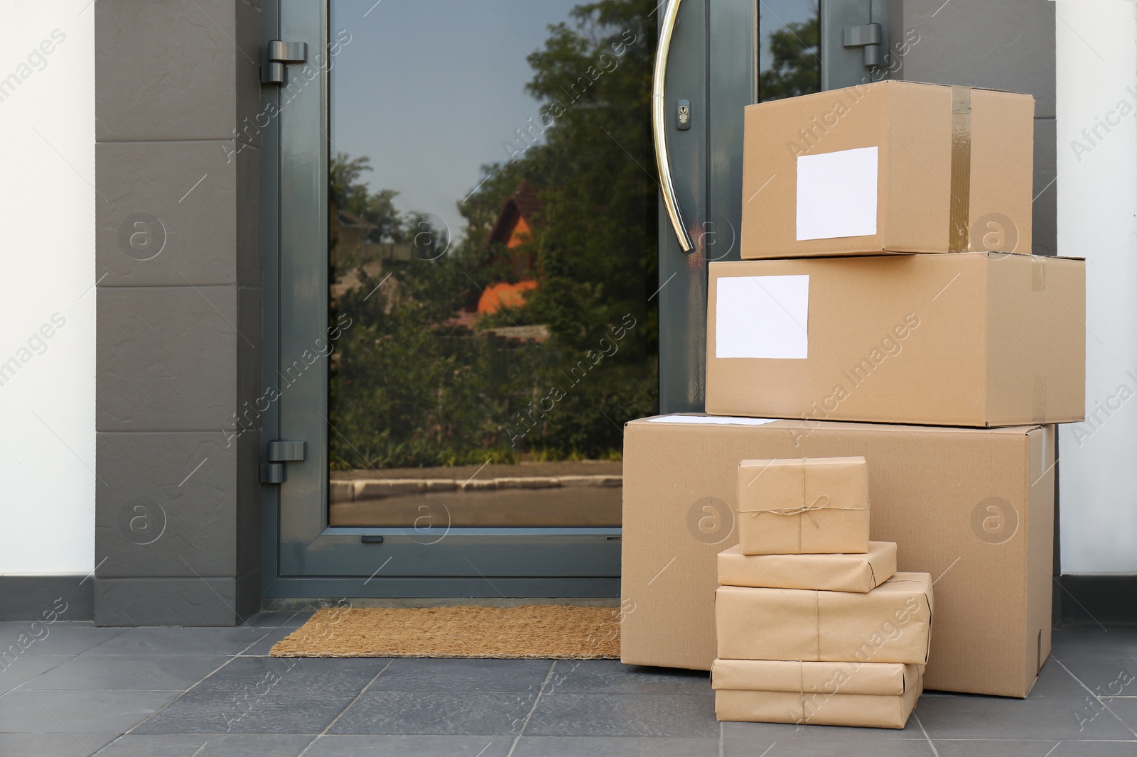 Photo of Cardboard boxes near door. Parcel delivery service