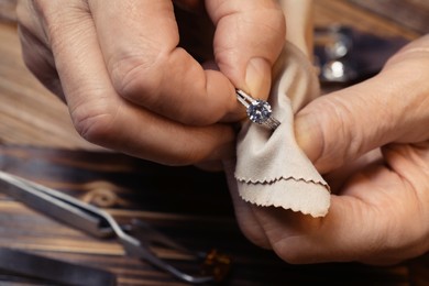 Photo of Professional jeweler working with ring, closeup view