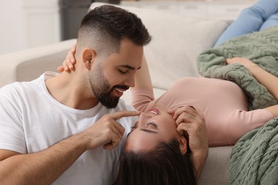 Photo of Affectionate young couple spending time together on sofa indoors